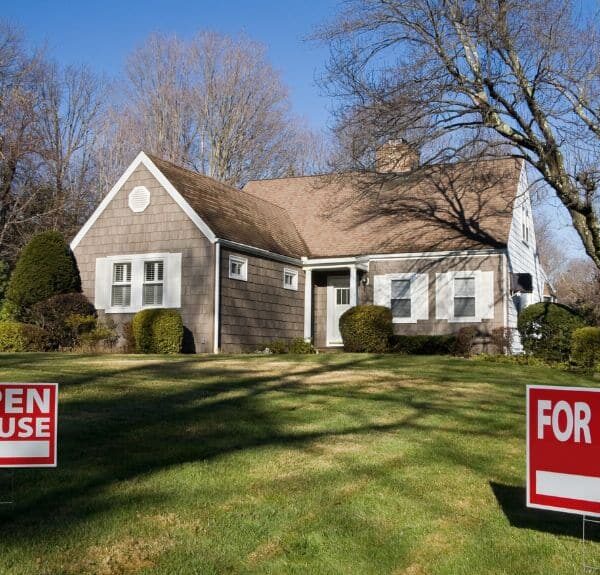 Elegant home in Loudoun County with well-maintained trees and a 'For Sale' sign on the front lawn, showcasing the value of professional tree pruning.