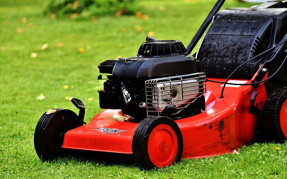 Red lawn mower on lawn